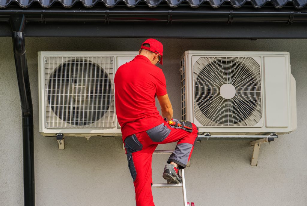 Caucasian HVAC Heating and Cooling Technician in His 40s Performing Scheduled Heat Pump and Air Condition Outdoor Units Service.